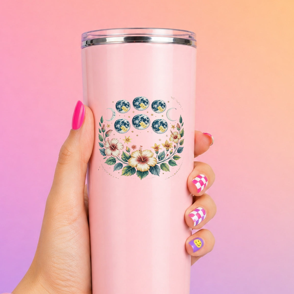 Moon Phases With Hibiscus Flowers UV DTF sticker applied to a tall pink tumbler on a pink and orange background