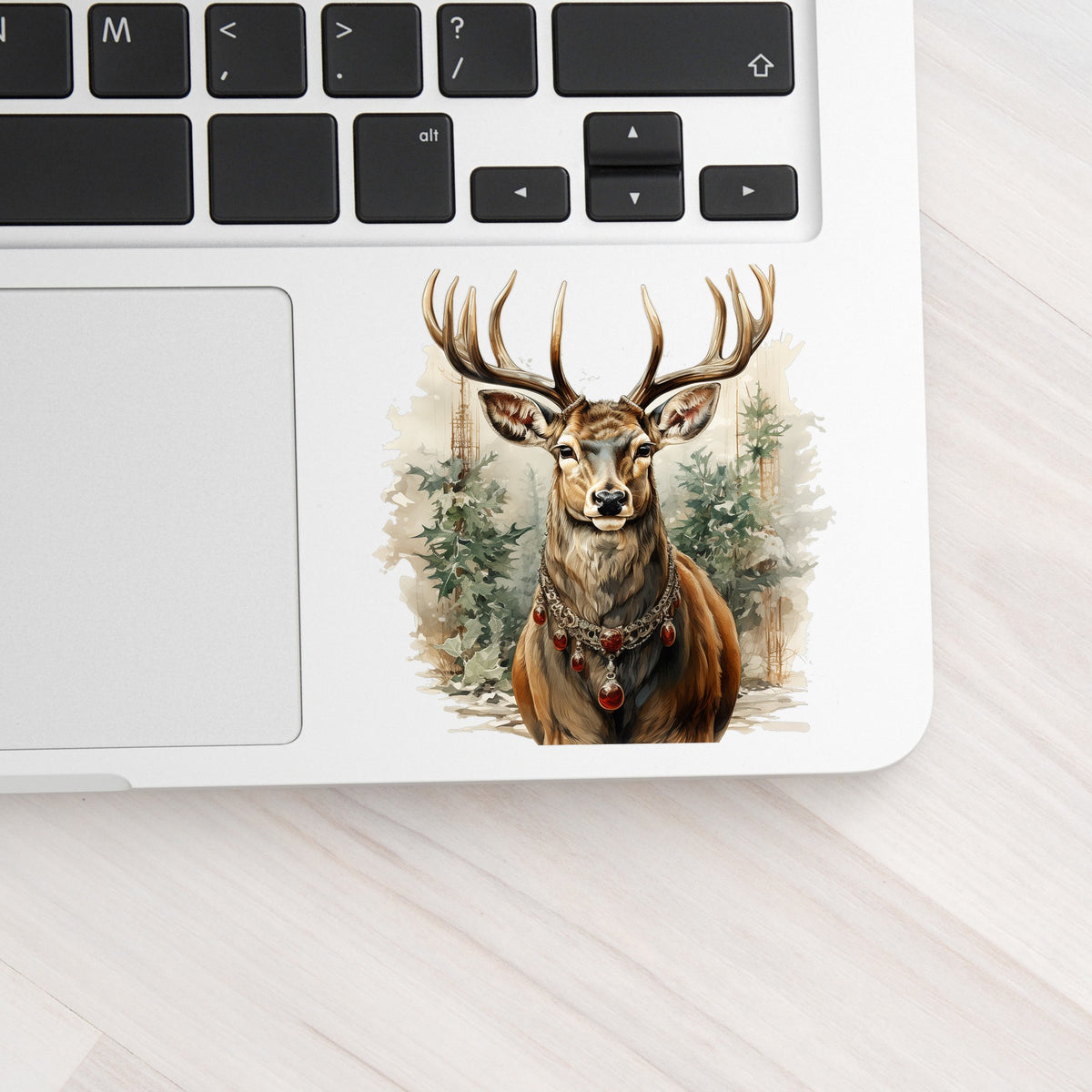 Stag With Jeweled Necklace UV DTF sticker applied to a silver laptop beside the keyboard