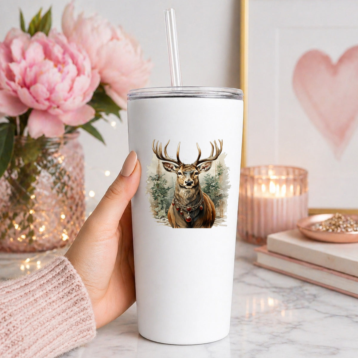 Stag With Jeweled Necklace UV DTF sticker applied to a white straw tumbler beside pink peonies