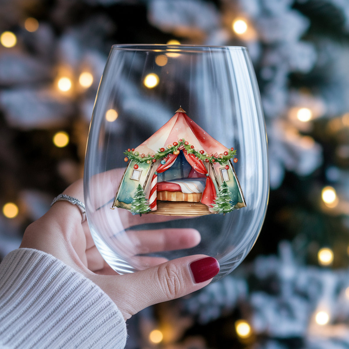 Christmas Glamping Tent UV DTF sticker applied to a stemless wine glass held in hand