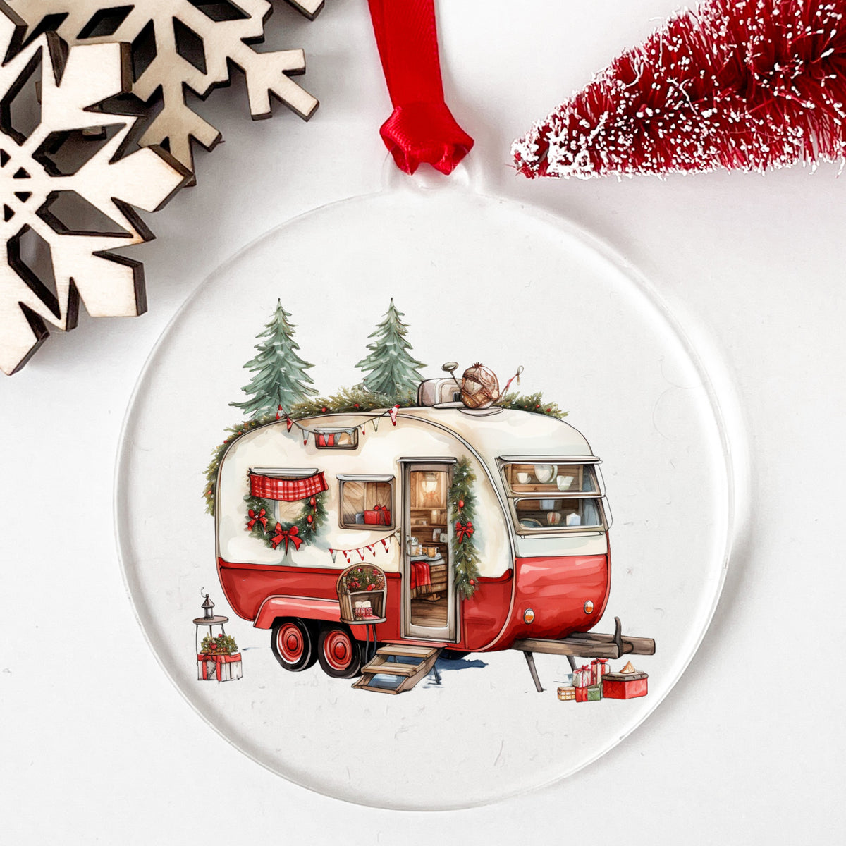 Vintage Christmas Camper Trailer UV DTF sticker applied to a clear round acrylic ornament with a red ribbon
