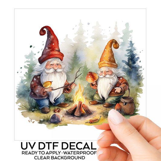 Gnomes At A Campfire UV DTF sticker on its backing card, held in hand