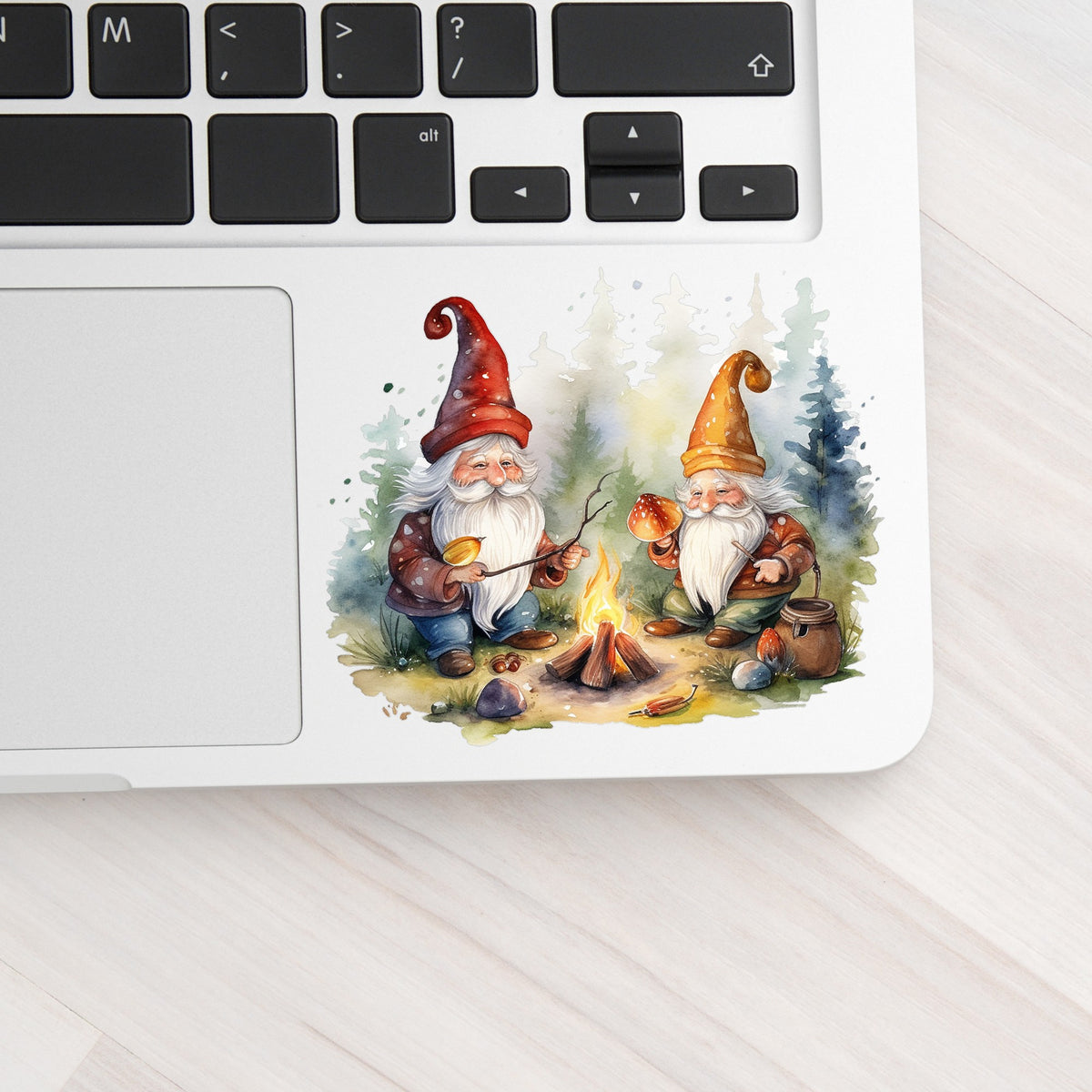 Gnomes At A Campfire UV DTF sticker applied to a silver laptop beside the keyboard