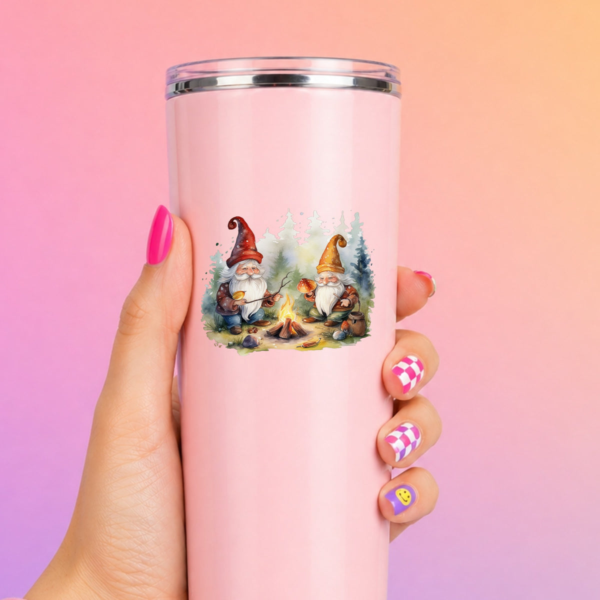 Gnomes At A Campfire UV DTF sticker applied to a tall pink tumbler on a pink and orange background