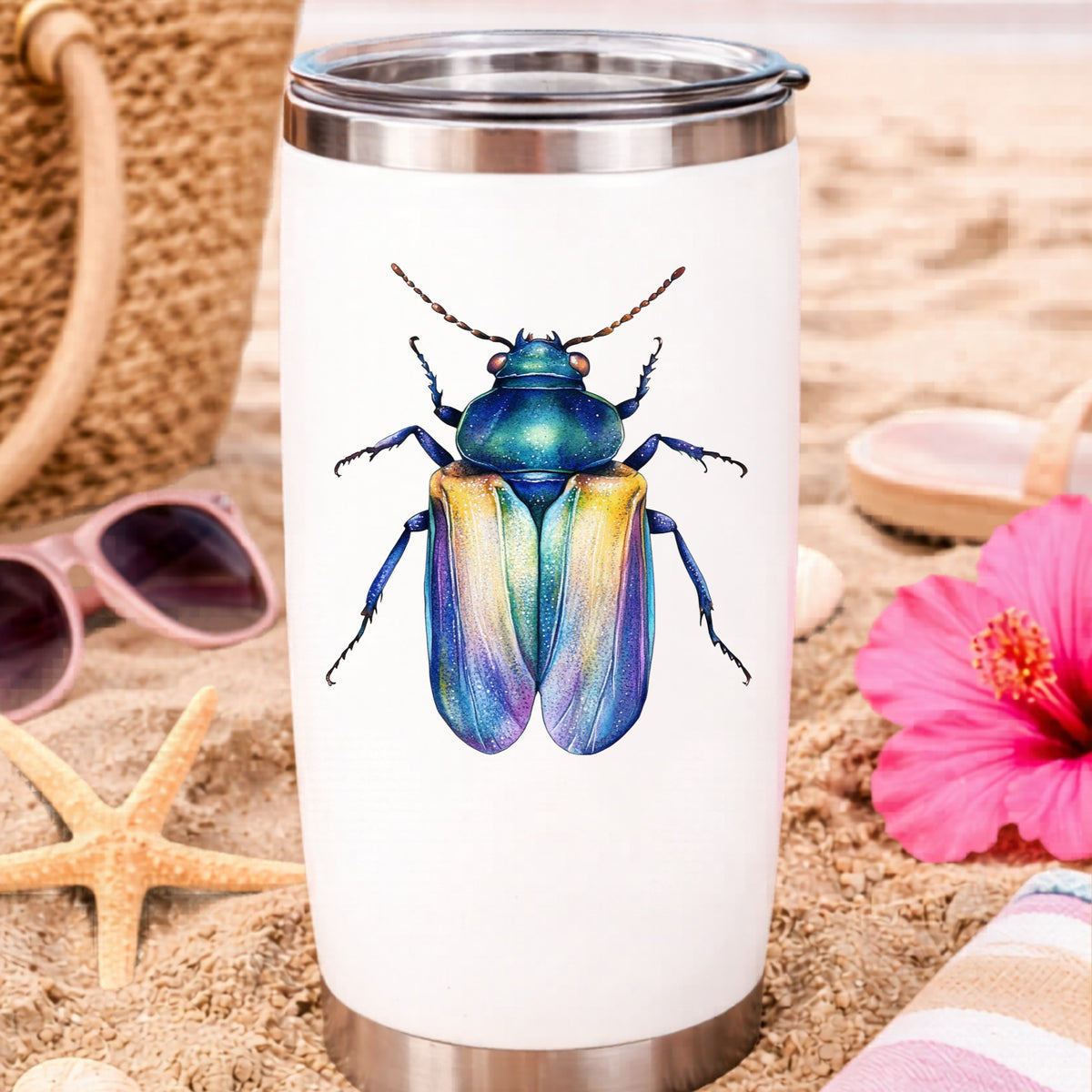 Gold And Blue Jewel Beetle UV DTF sticker applied to a white travel tumbler on beach sand