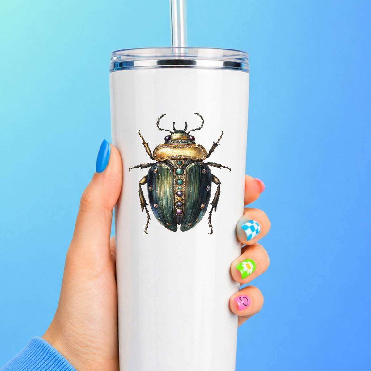 Jeweled Gold Scarab Beetle UV DTF sticker applied to a white straw tumbler on a blue background