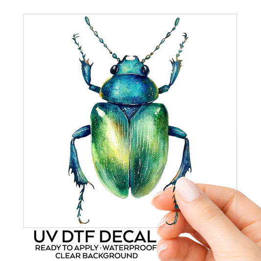 Emerald Green Beetle UV DTF sticker on its backing card, held in hand