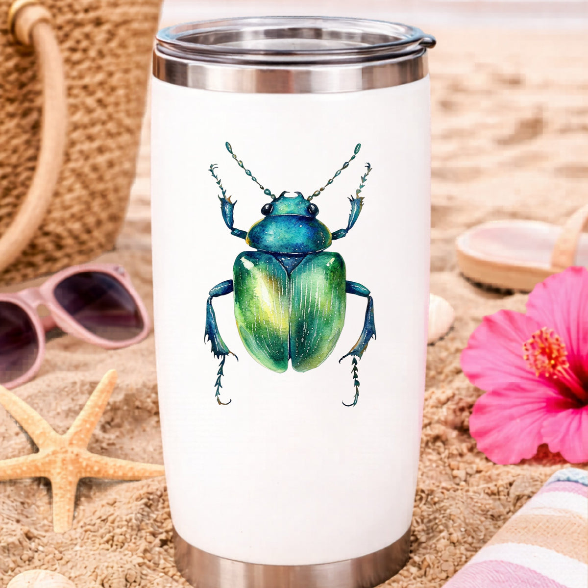 Emerald Green Beetle UV DTF sticker applied to a white travel tumbler on beach sand