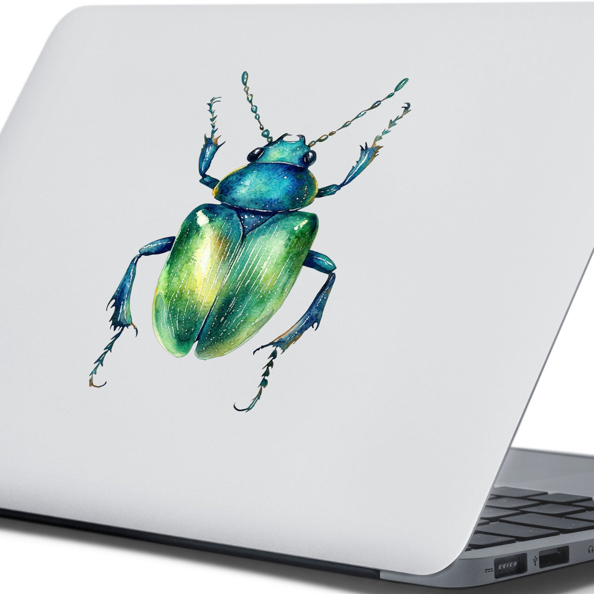 Emerald Green Beetle UV DTF sticker applied to the lid of a silver laptop