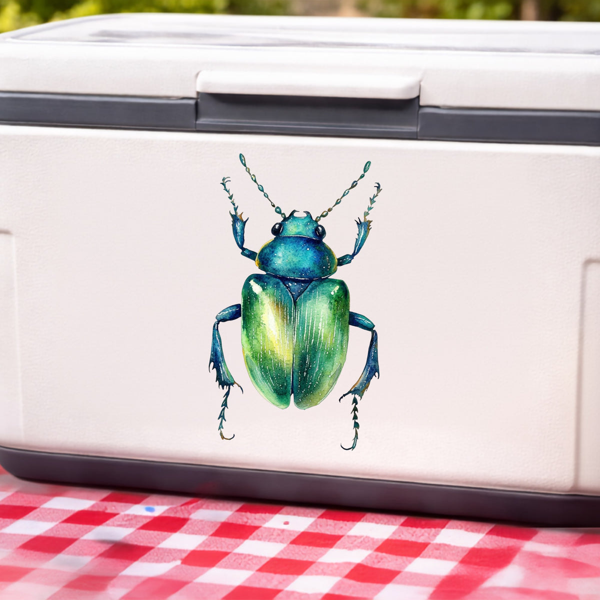 Emerald Green Beetle UV DTF sticker applied to a white cooler on a red gingham cloth