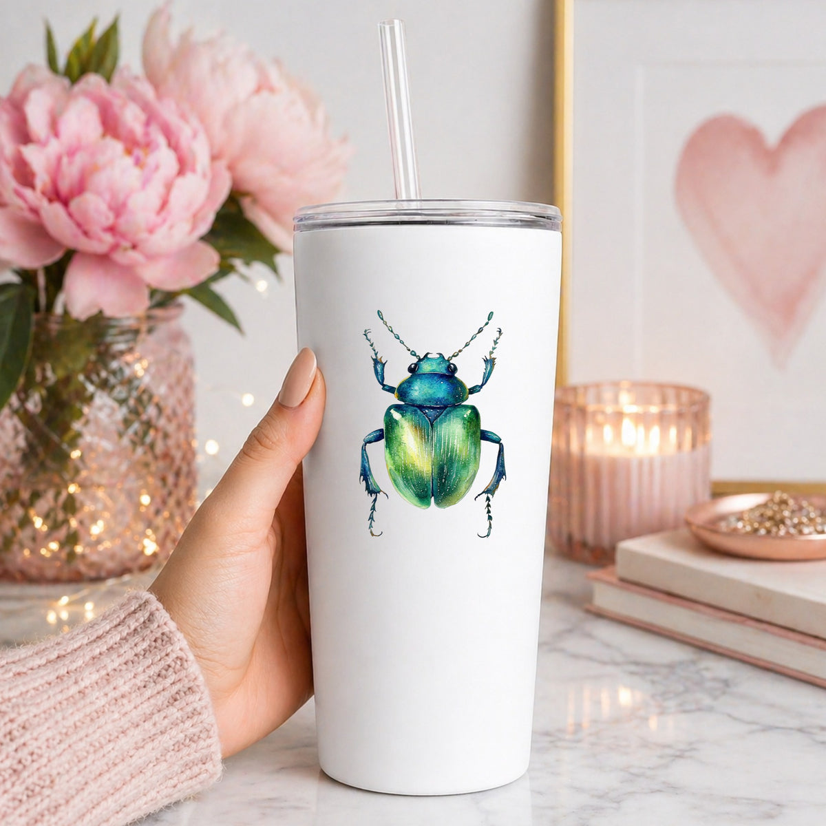Emerald Green Beetle UV DTF sticker applied to a white straw tumbler beside pink peonies