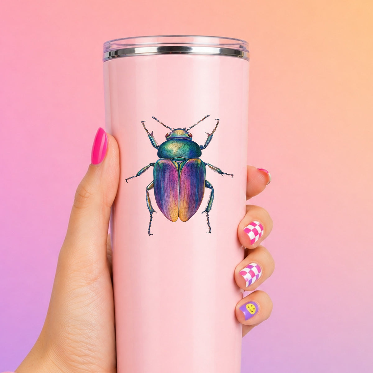 Rainbow Iridescent Beetle UV DTF sticker applied to a tall pink tumbler on a pink and orange background