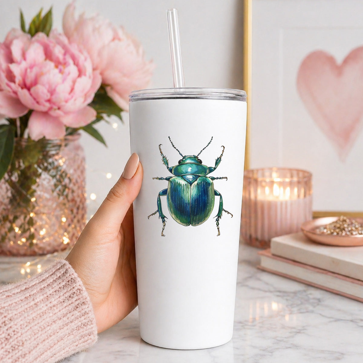 Striped Teal Beetle UV DTF sticker applied to a white straw tumbler beside pink peonies
