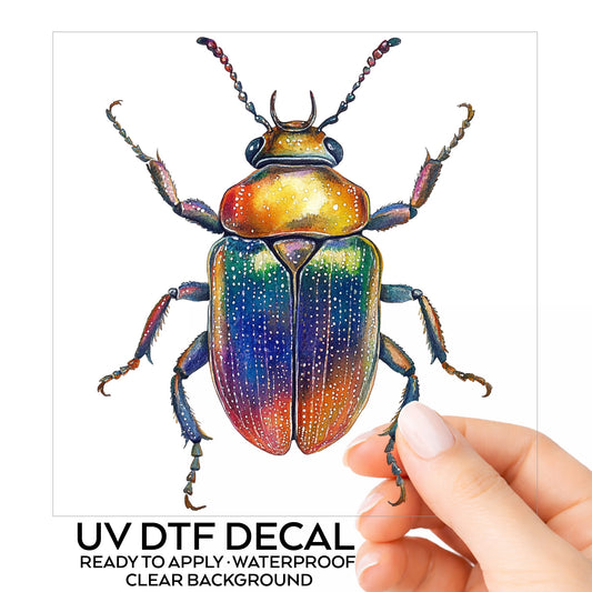 Horned Rainbow Beetle UV DTF sticker on its backing card, held in hand
