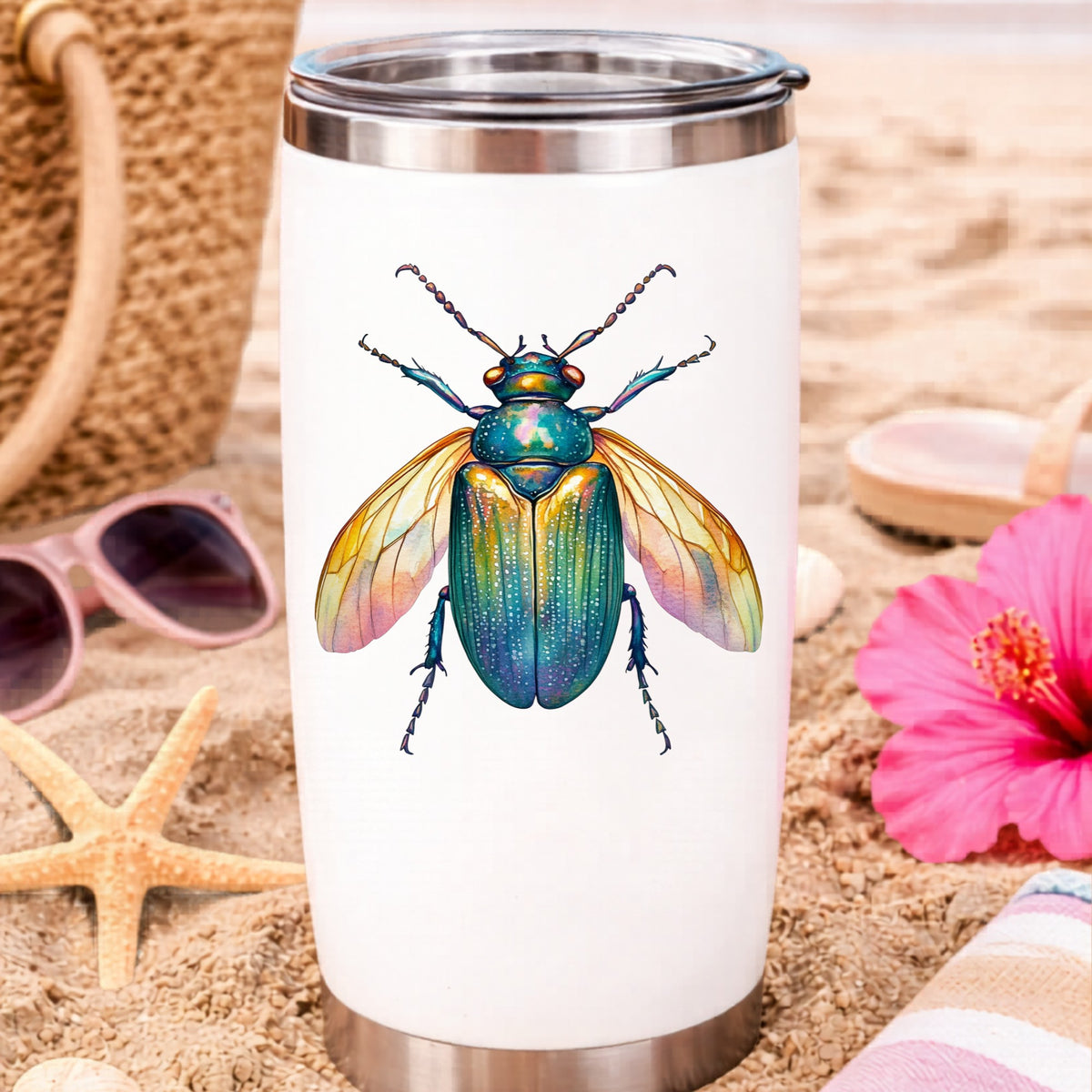Golden Winged Flying Beetle UV DTF sticker applied to a white travel tumbler on beach sand