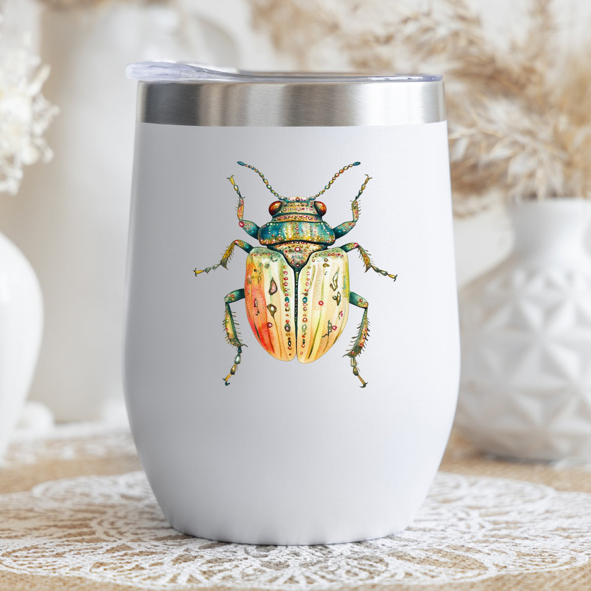 Cream And Coral Jeweled Beetle UV DTF sticker applied to a white stemless tumbler with a lid