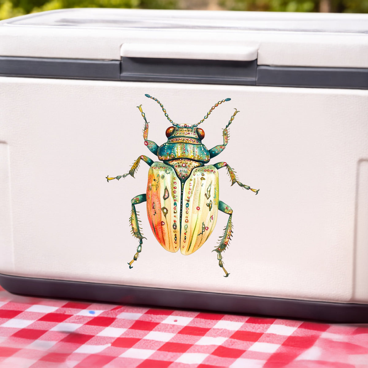 Cream And Coral Jeweled Beetle UV DTF sticker applied to a white cooler on a red gingham cloth