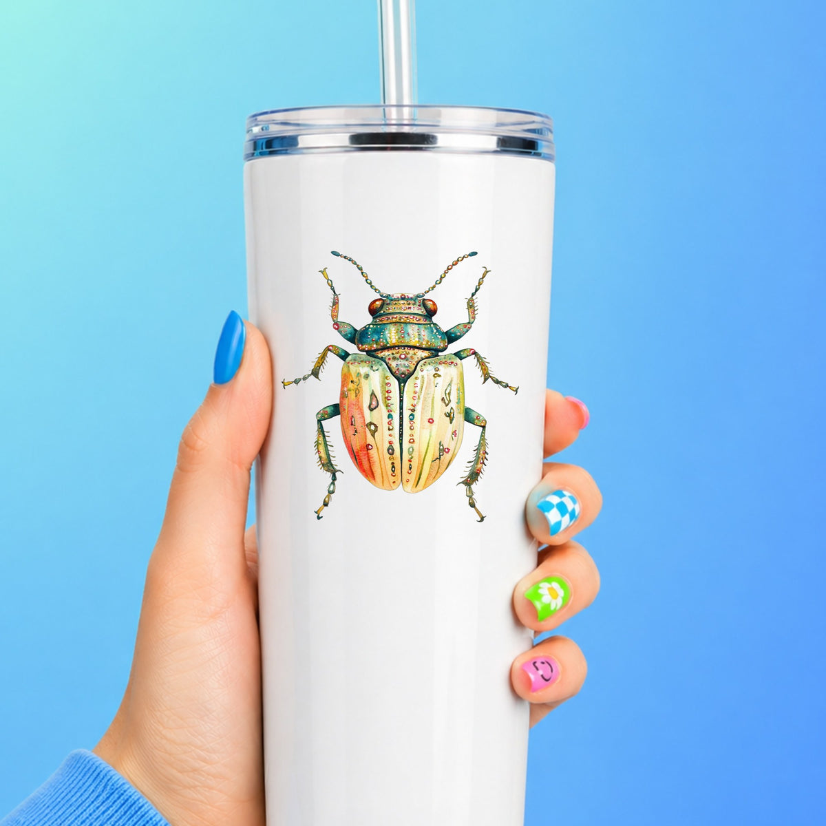Cream And Coral Jeweled Beetle UV DTF sticker applied to a white straw tumbler on a blue background