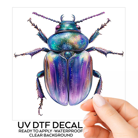 Violet Sparkle Beetle UV DTF sticker on its backing card, held in hand