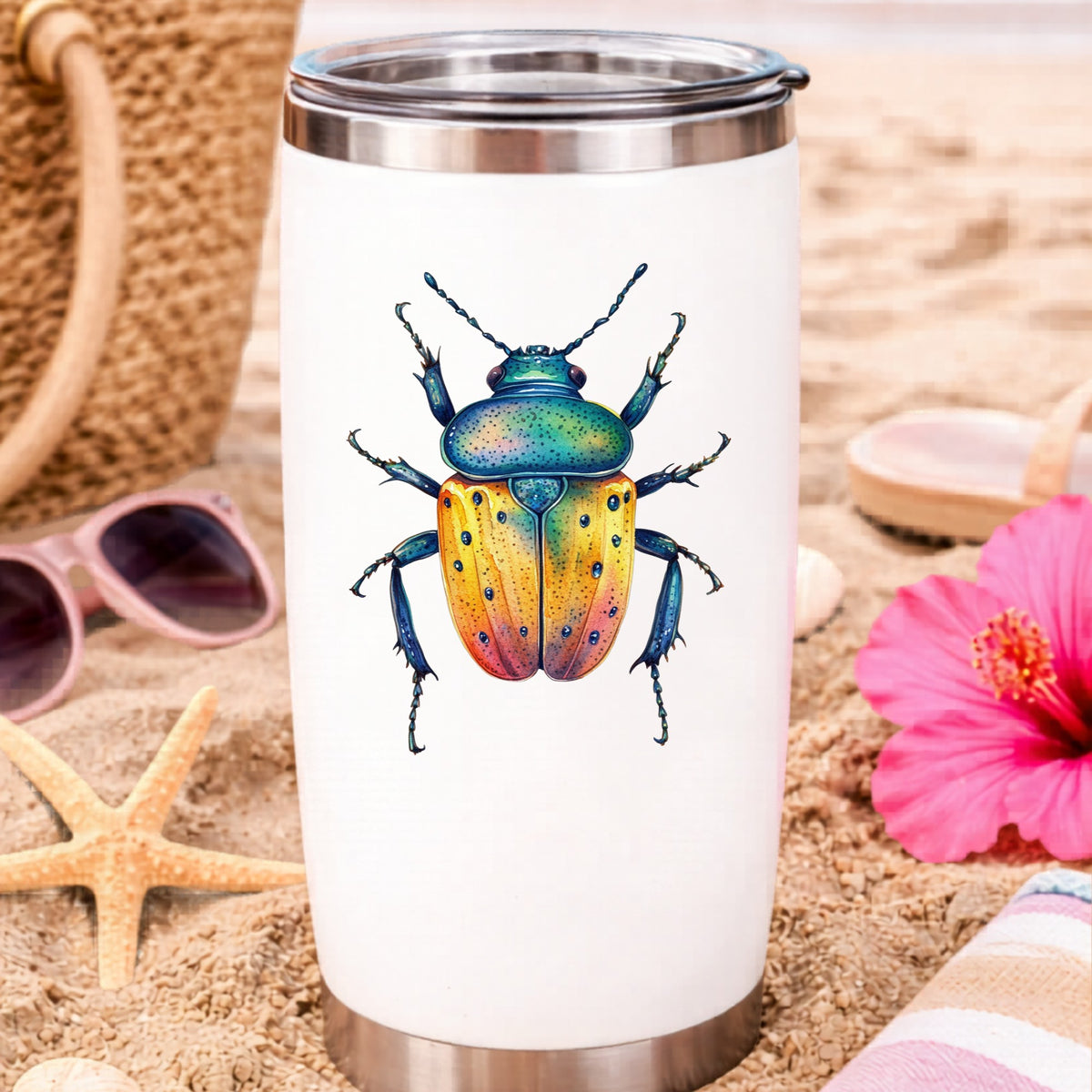 Orange And Blue Spotted Beetle UV DTF sticker applied to a white travel tumbler on beach sand