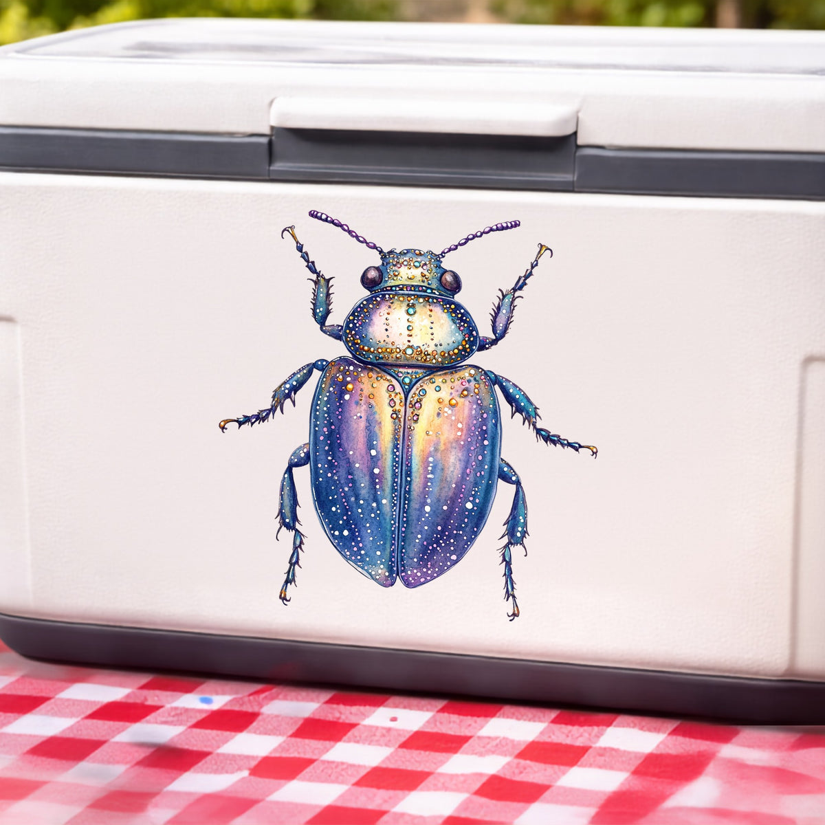 Lavender Jeweled Beetle UV DTF sticker applied to a white cooler on a red gingham cloth
