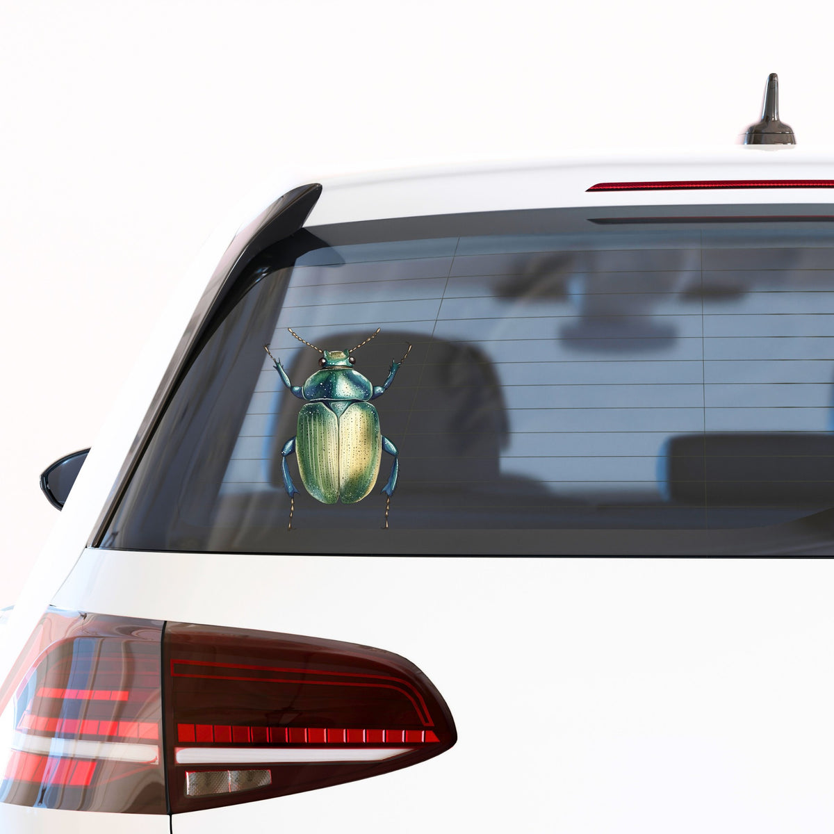 Green Scarab Beetle UV DTF sticker applied to the rear window of a white car