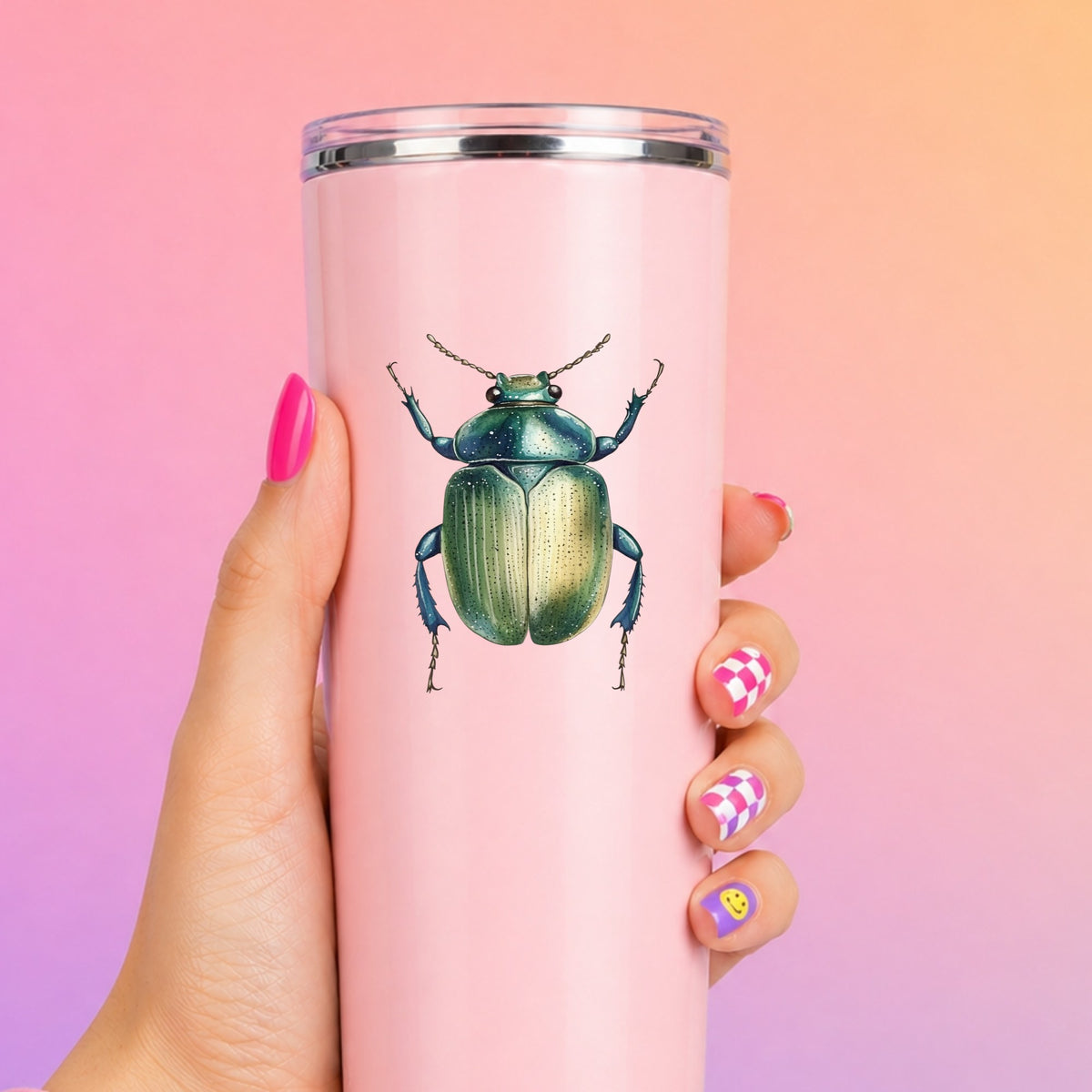 Green Scarab Beetle UV DTF sticker applied to a tall pink tumbler on a pink and orange background