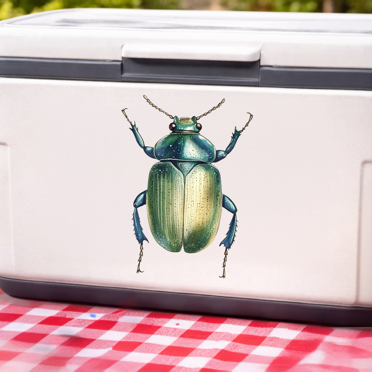 Green Scarab Beetle UV DTF sticker applied to a white cooler on a red gingham cloth
