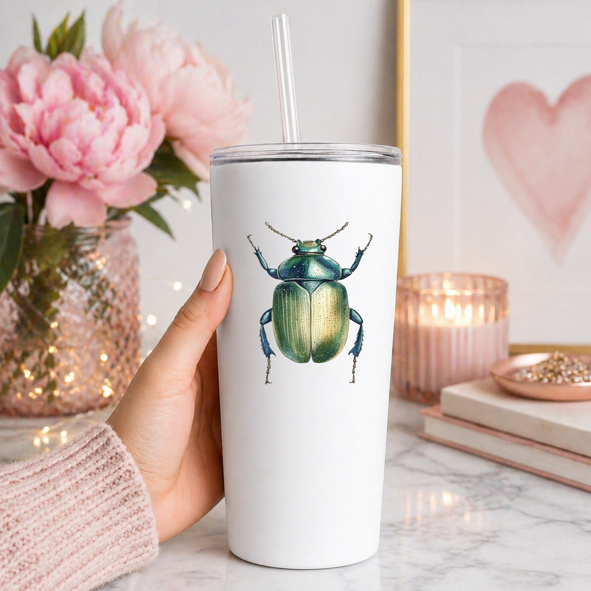 Green Scarab Beetle UV DTF sticker applied to a white straw tumbler beside pink peonies