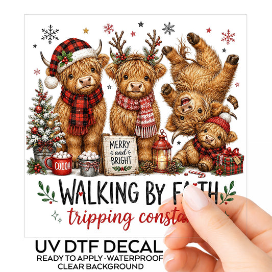 Walking By Faith Christmas Highland Cows UV DTF sticker on its backing card, held in hand