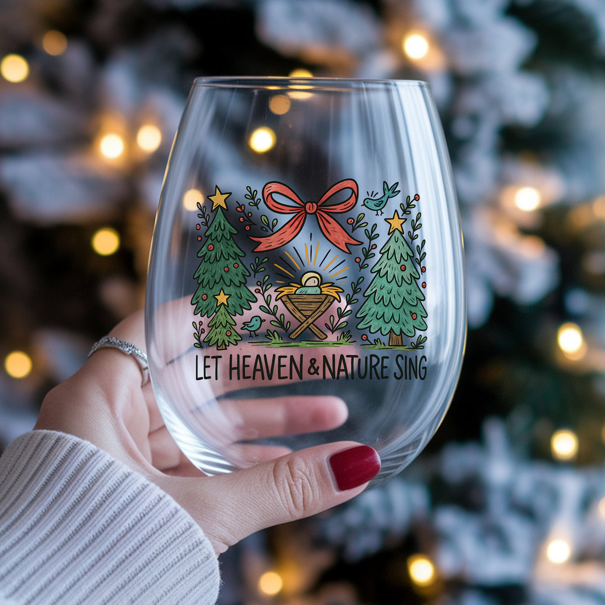 Let Heaven And Nature Sing Nativity UV DTF sticker applied to a stemless wine glass held in hand