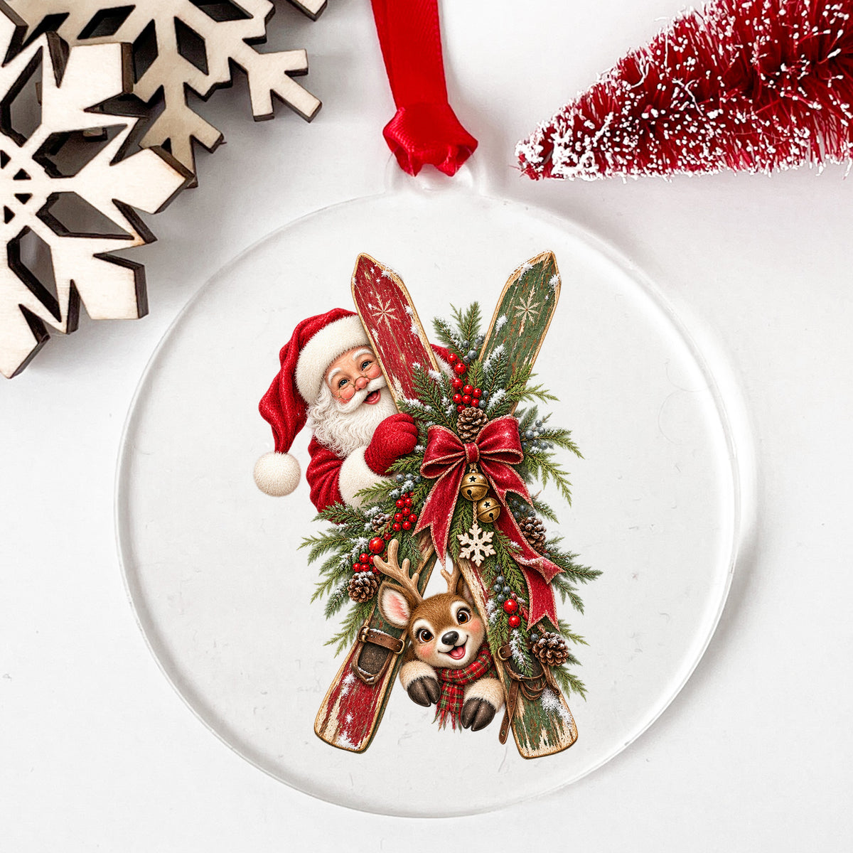 Santa And Reindeer With Wooden Skis UV DTF sticker applied to a clear round acrylic ornament with a red ribbon