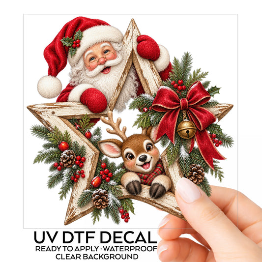 Santa And Reindeer With Wooden Star Wreath UV DTF sticker on its backing card, held in hand