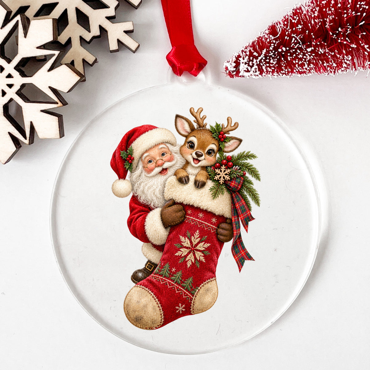 Santa And Reindeer With Red Stocking UV DTF sticker applied to a clear round acrylic ornament with a red ribbon
