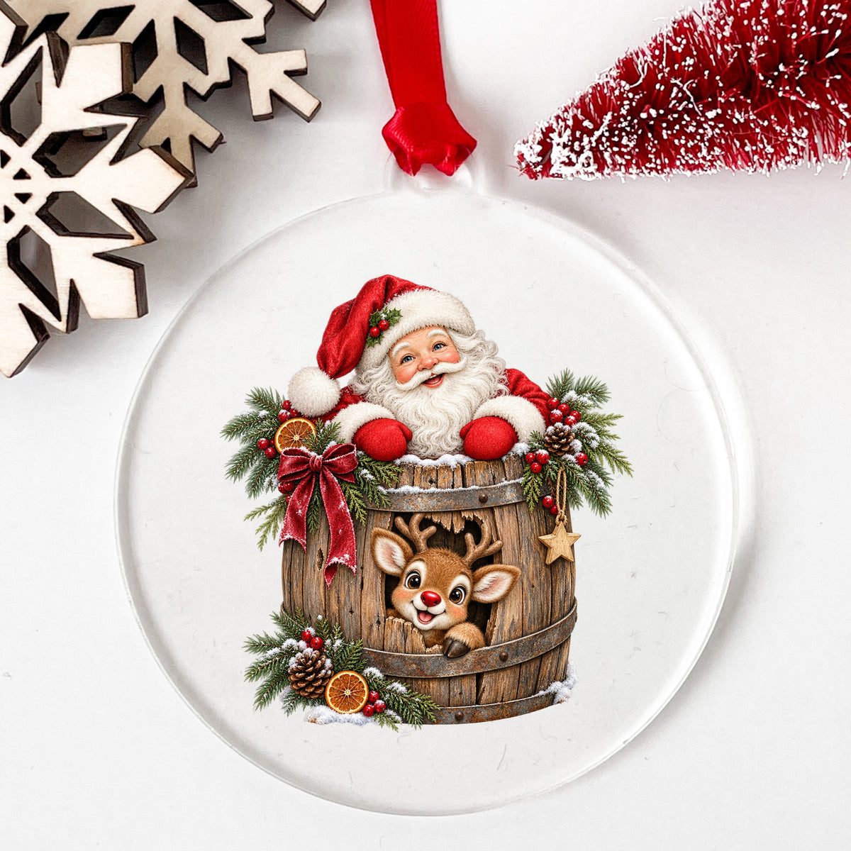 Santa And Reindeer In Wooden Barrel UV DTF sticker applied to a clear round acrylic ornament with a red ribbon
