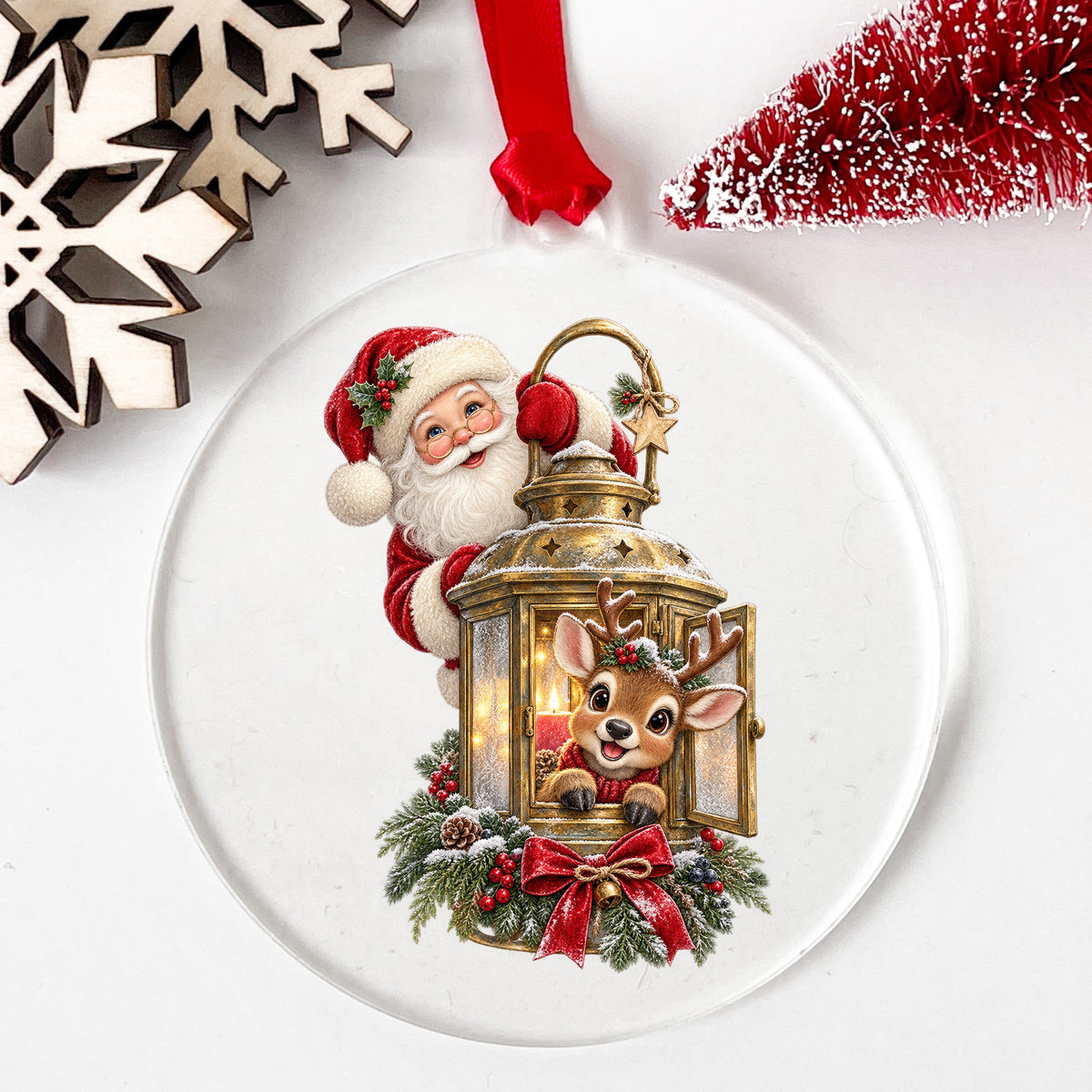 Santa And Reindeer With Gold Lantern UV DTF sticker applied to a clear round acrylic ornament with a red ribbon