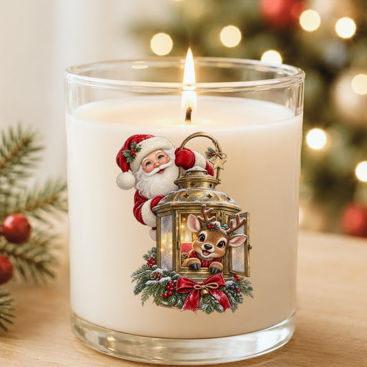 Santa And Reindeer With Gold Lantern UV DTF sticker applied to a white candle in a glass holder near Christmas lights
