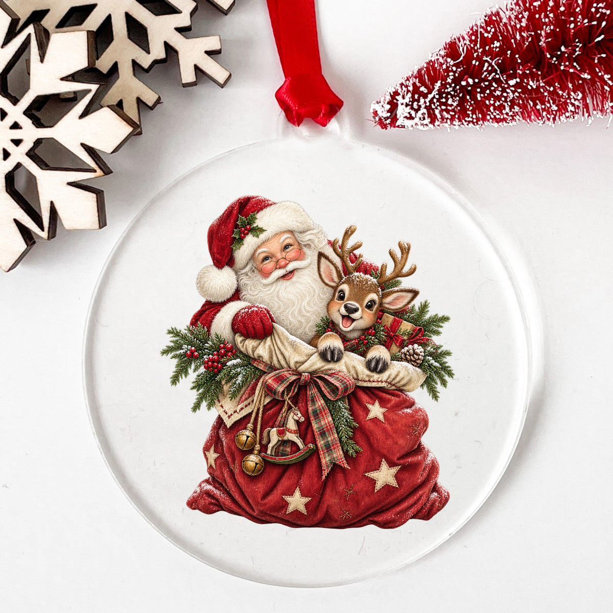 Santa With Red Toy Sack And Reindeer UV DTF sticker applied to a clear round acrylic ornament with a red ribbon