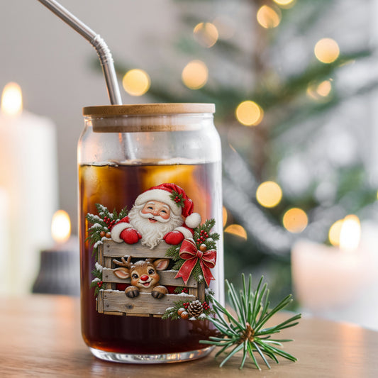 Santa And Reindeer With Wooden Crate UV DTF sticker applied to a glass can cup of iced coffee with a straw