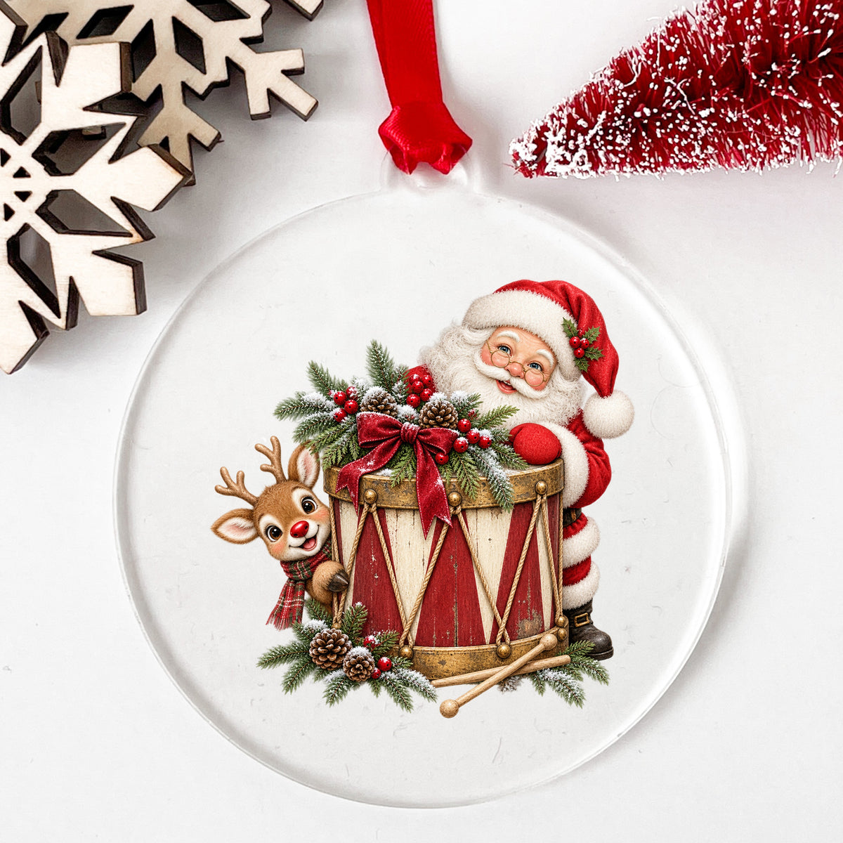 Santa And Reindeer With Vintage Toy Drum UV DTF sticker applied to a clear round acrylic ornament with a red ribbon