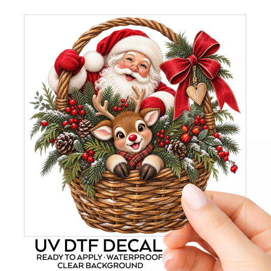 Santa And Reindeer In Wicker Basket UV DTF sticker on its backing card, held in hand