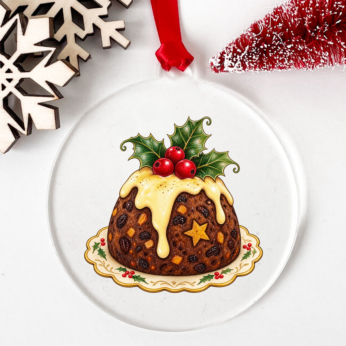 Christmas Pudding With Holly UV DTF sticker applied to a clear round acrylic ornament with a red ribbon