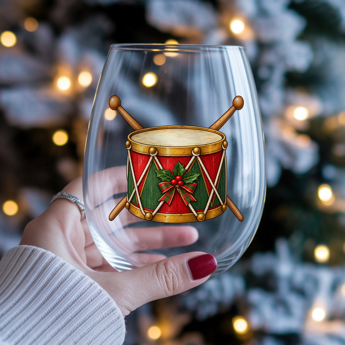 Vintage Toy Drum With Drumsticks UV DTF sticker applied to a stemless wine glass held in hand