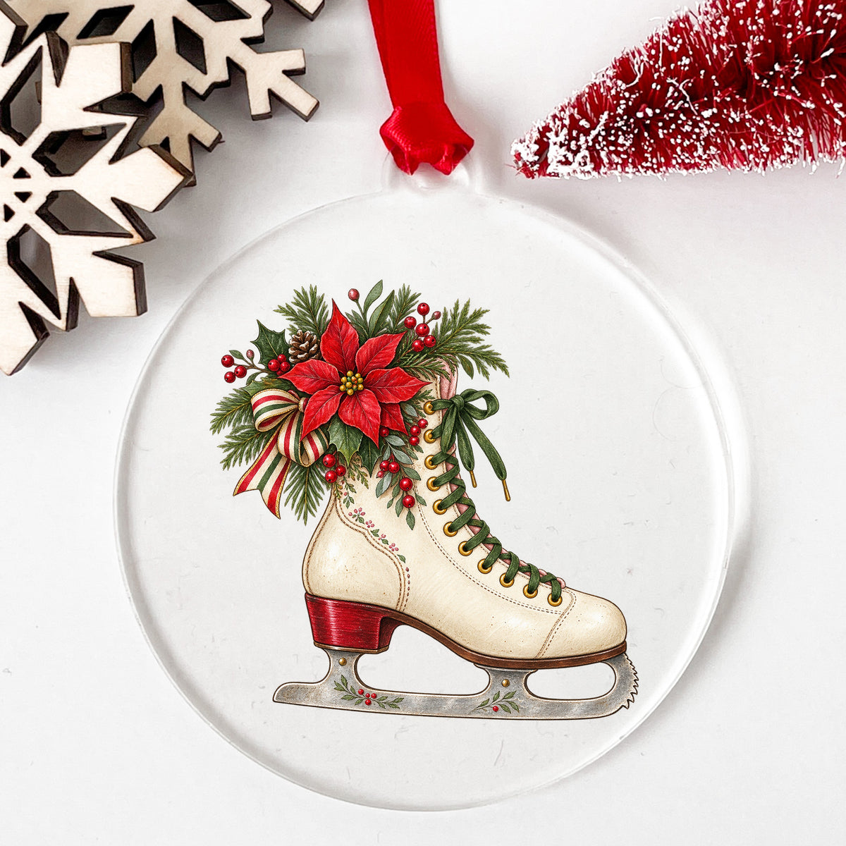 Vintage Ice Skate With Poinsettia UV DTF sticker applied to a clear round acrylic ornament with a red ribbon