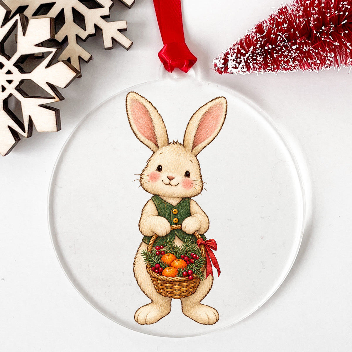 Bunny Holding Basket Of Oranges UV DTF sticker applied to a clear round acrylic ornament with a red ribbon