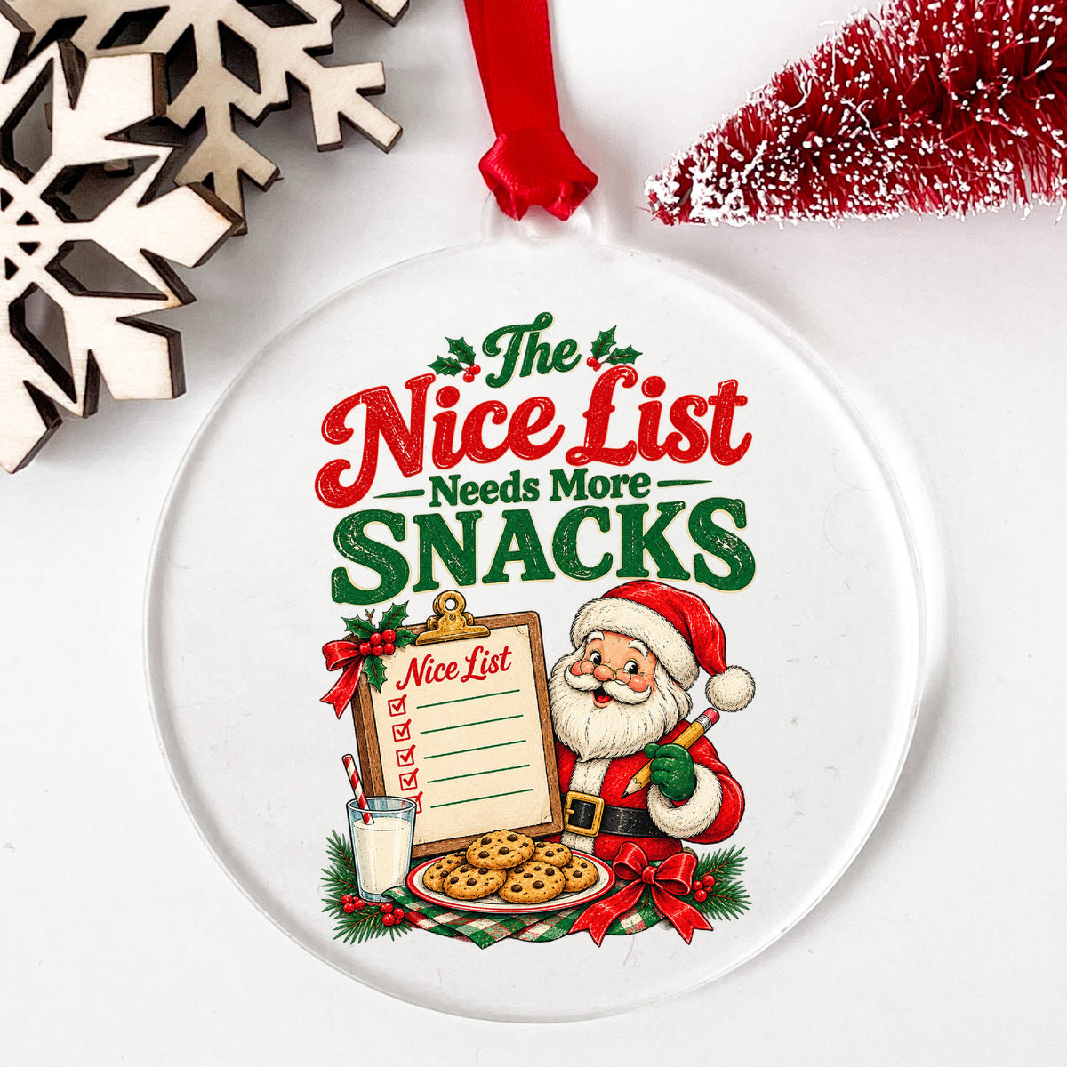 Nice List Needs More Snacks Santa UV DTF sticker applied to a clear round acrylic ornament with a red ribbon