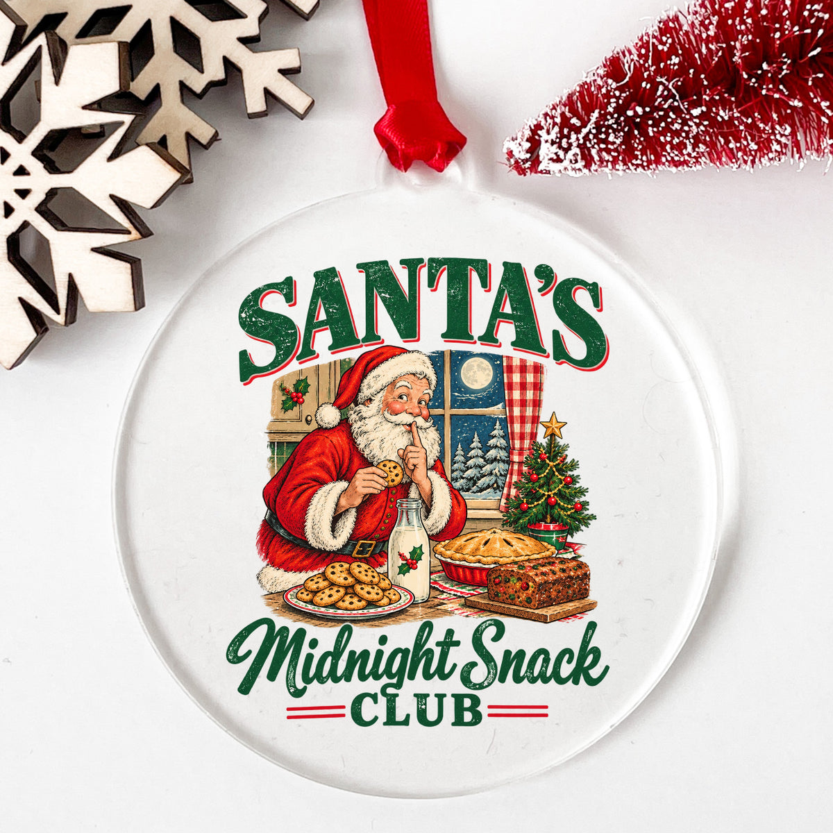Santa's Midnight Snack Club UV DTF sticker applied to a clear round acrylic ornament with a red ribbon