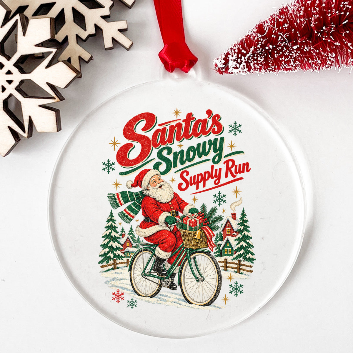 Santa's Snowy Supply Run Bicycle UV DTF sticker applied to a clear round acrylic ornament with a red ribbon
