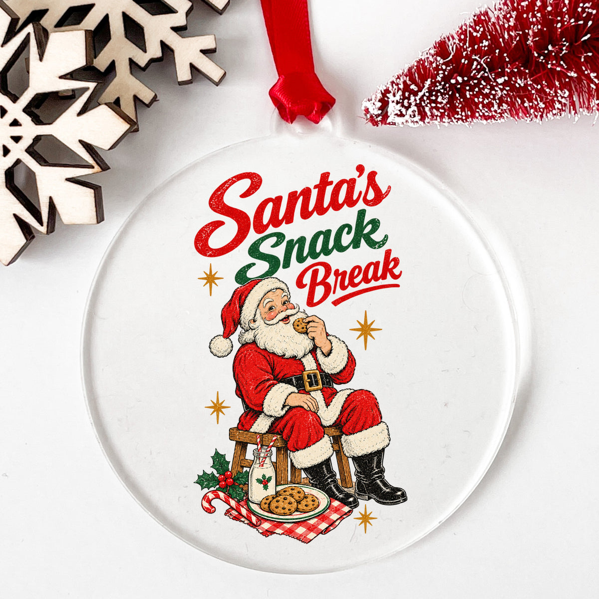 Santa's Snack Break Cookies UV DTF sticker applied to a clear round acrylic ornament with a red ribbon