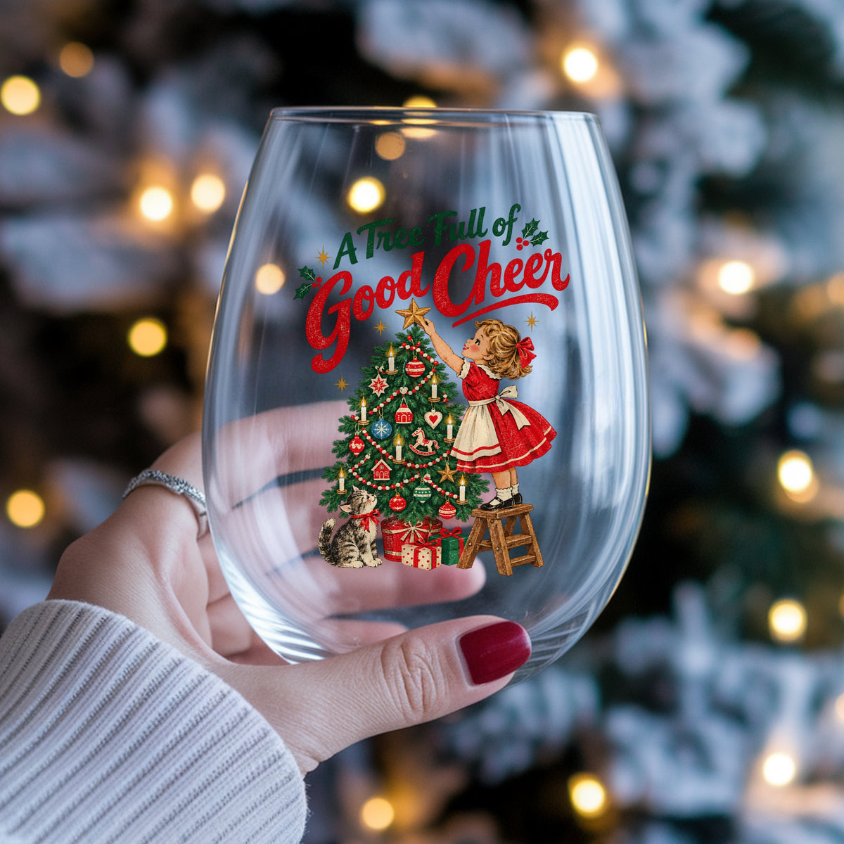 A Tree Full Of Good Cheer UV DTF sticker applied to a stemless wine glass held in hand